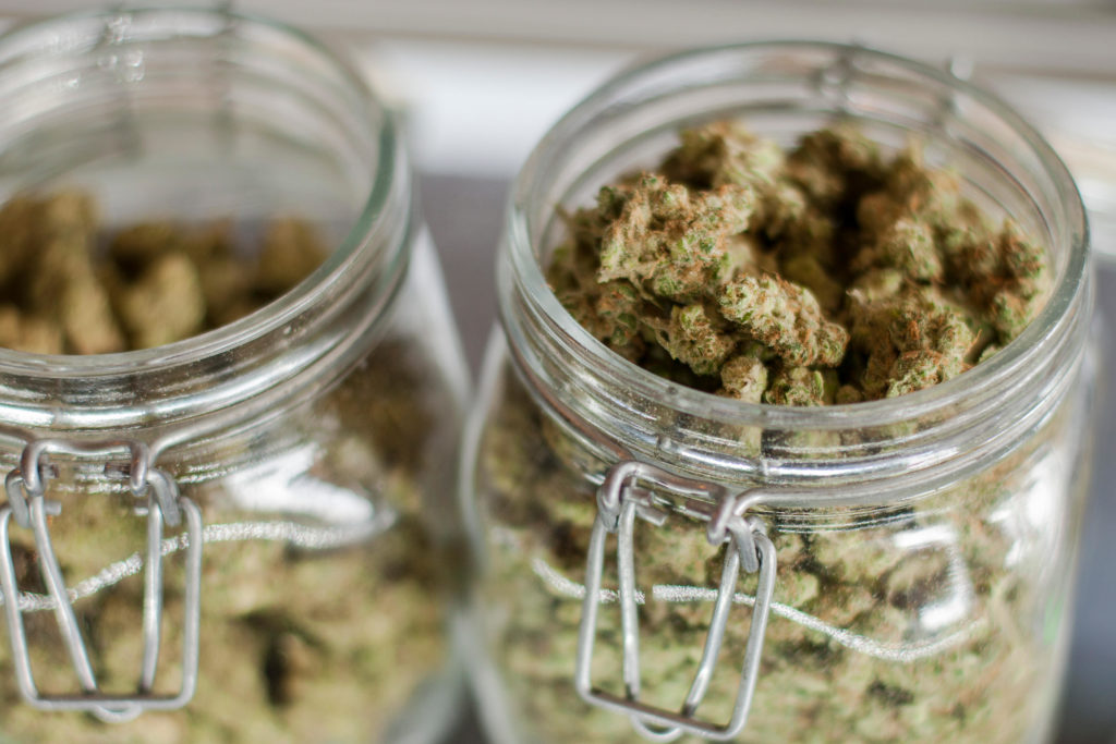 Glass jars full of marijuana buds on display and for sale at a